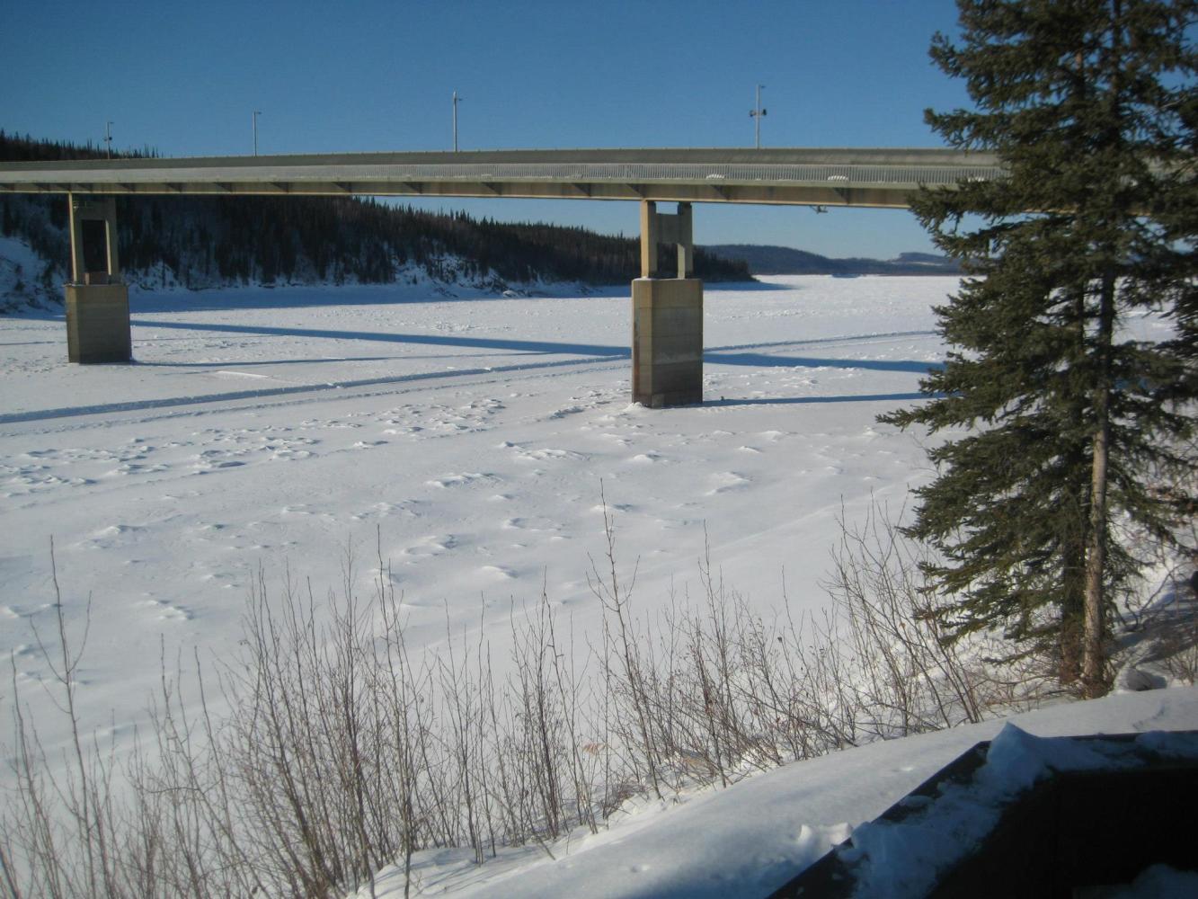 a sign on the side of a snow covered bridge