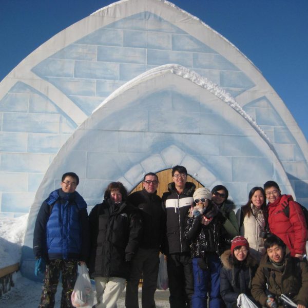Tour group posing in front of ice structure during Fairbanks Alaska winter tour