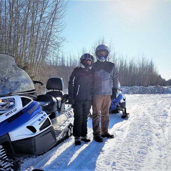 Two menstanding beside snowmobile on snowy trail near Fairbanks Alaska