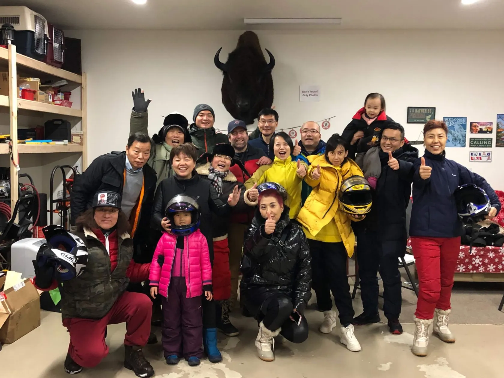 Tour guests celebrating at the Arctic Circle sign in Alaska