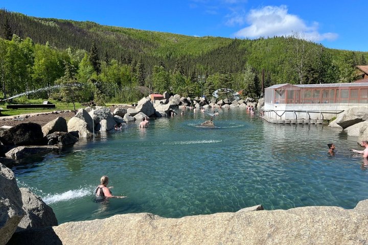 a group of people standing next to a body of water