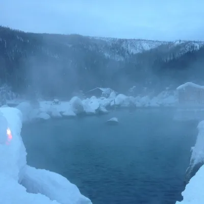 a person riding a wave on top of a snow covered mountain