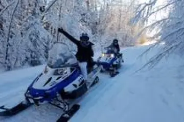 a group of people riding skis across snow covered ground
