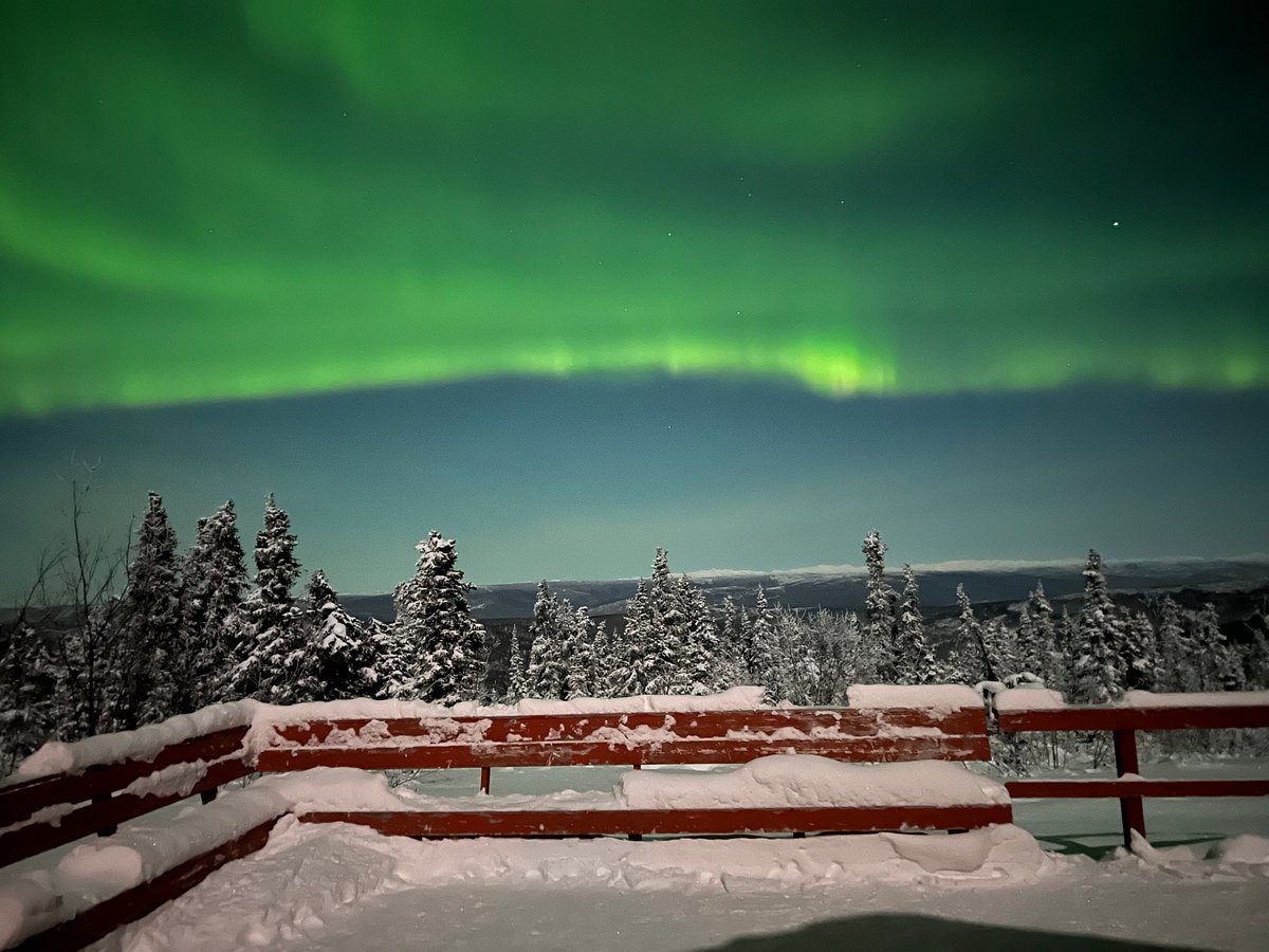 Bright northern lights sweeping over viewing platform near Fairbanks Alaska