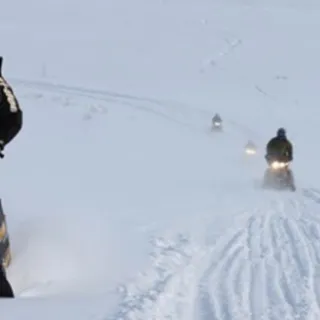 a man riding a snowboard down a snow covered slope