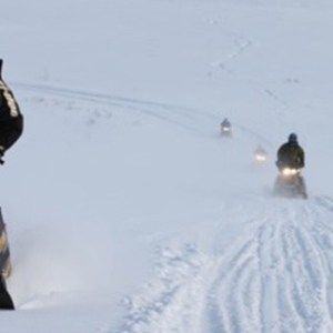 a man riding a snowboard down a snow covered slope