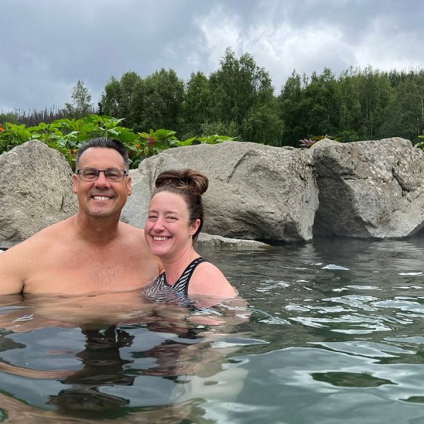 Couple posing in freshwater with rocks in background near on Alaska Wild Lights Tour