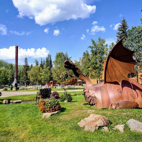 Wooden dragon sculpture on display in scenic Alaska landscape