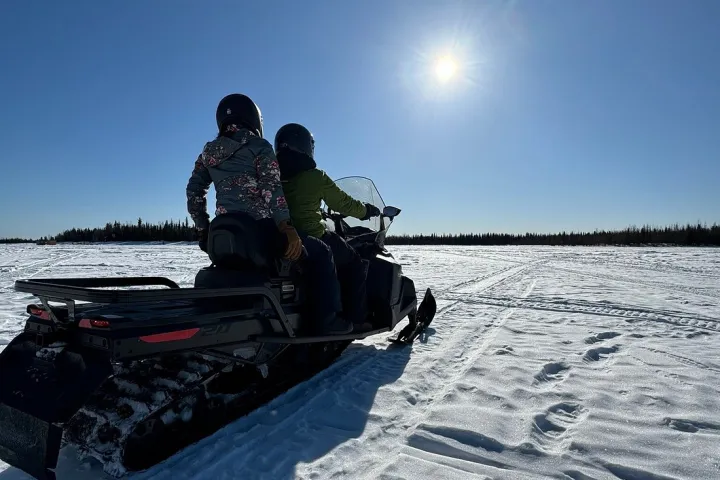 a man riding a snowboard down a snow covered slope