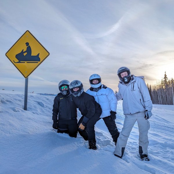 a group of people standing on top of a snow covered slope