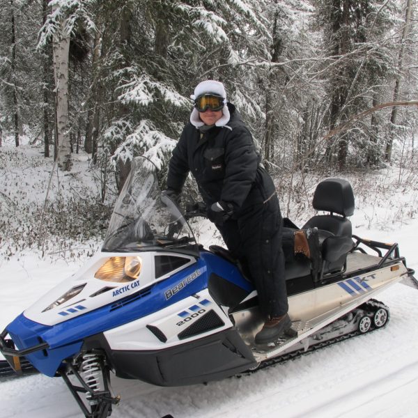 Man posing on snowmobile during Alaska Wild Lights tour near Fairbanks Alaska
