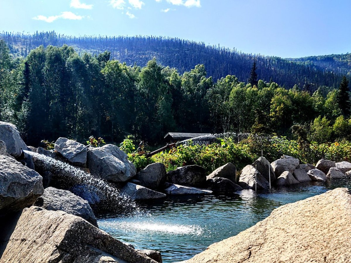 Rocky mountain with trees in background and water in foreground near Fairbanks Alaska