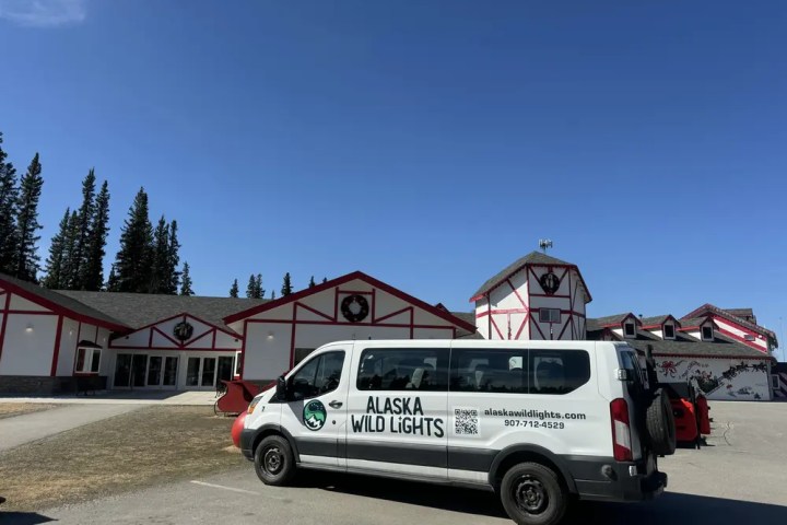 Van parked in front of red and white building under blue sky.